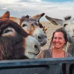 Lauren McCain laughing with three happy donkeys